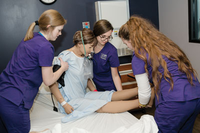 Nursing students work in a simulation lab