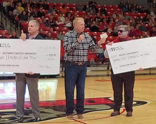 Bank of Bolivar presents checks to the presidents of SBU and Drury.