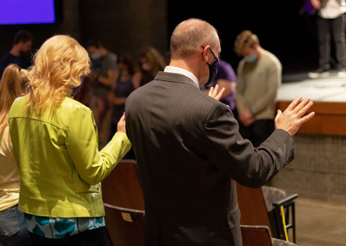 Dr. Brad Johnson and his wife, Laura, pray.