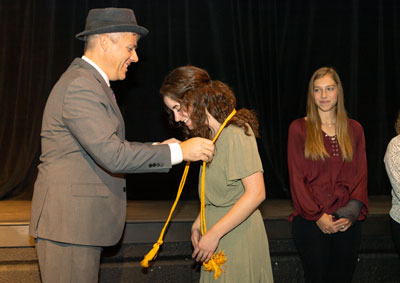 Dr. Lee Skinkle presents honors cords to Hailey Campbell