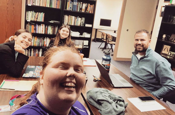 Debate students sitting around a table.