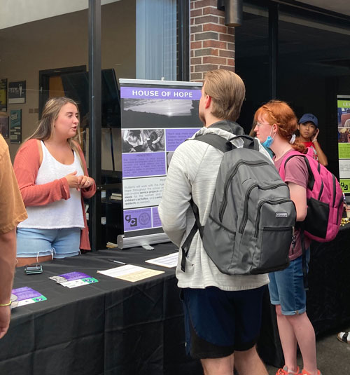People gather around the House of Hope booth