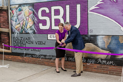 SBU Student Association President Samantha Martin and SBU President Dr. Eric A. Turner cut the ribbon to dedicate the S.A. Inaugural Mural.