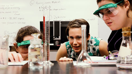 Dr. Danielle West conducting chemistry experiment with students