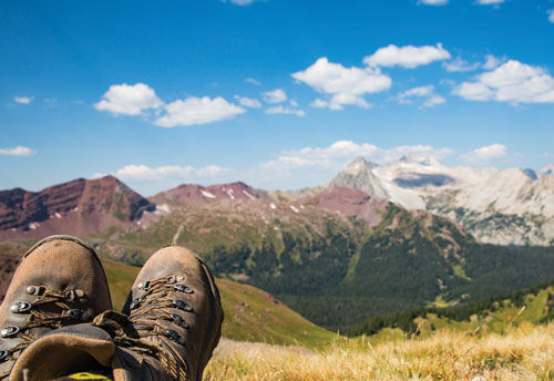 view of hiking boots overlooking mountain scene
