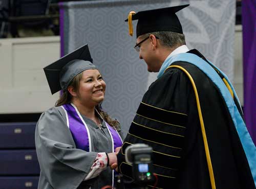 CJ Noelle Hobbs is the first SBU graduate to receive a diploma from President Dr. Eric A. Turner.