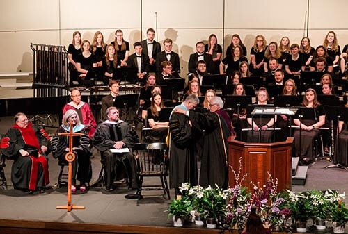 SBU Board of Trustees chairman, Mark Rains, places the presidential medallion on SBU's 25th president, Dr. Eric A. Turner.