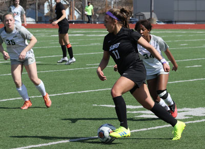 SBU Women's Soccer player dribbling the ball