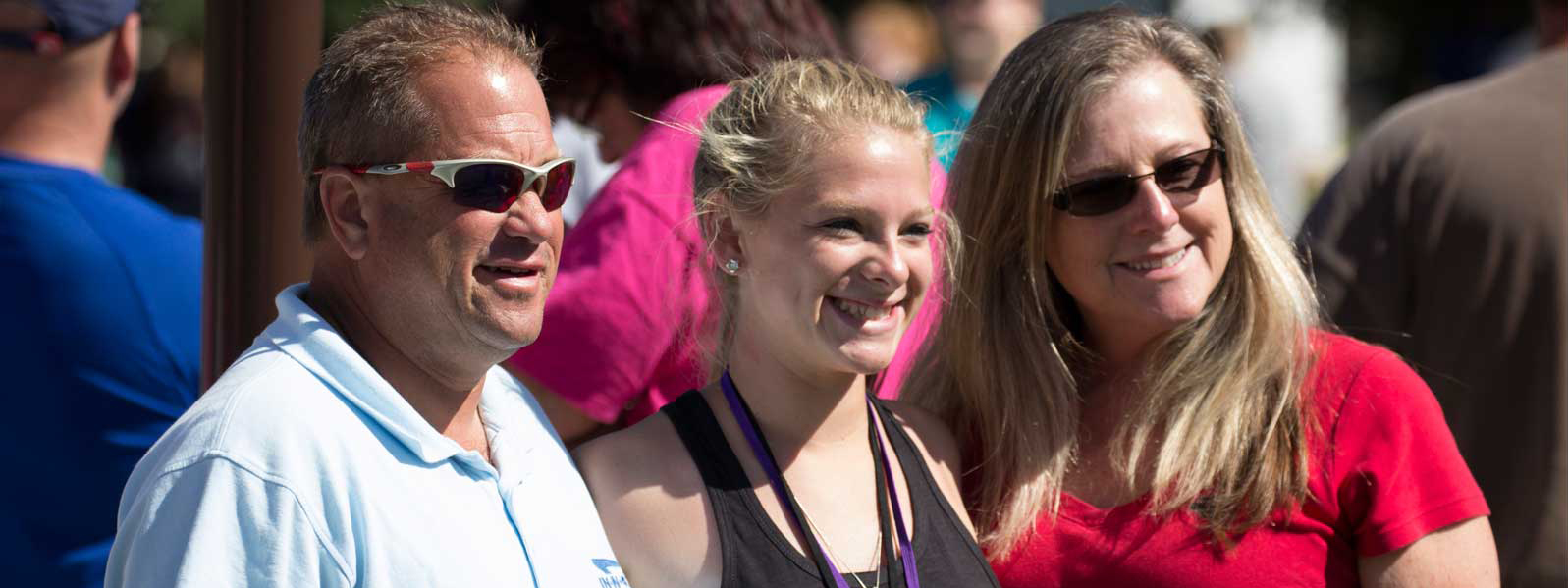 mom, dad, and student pose for picture on move-in day
