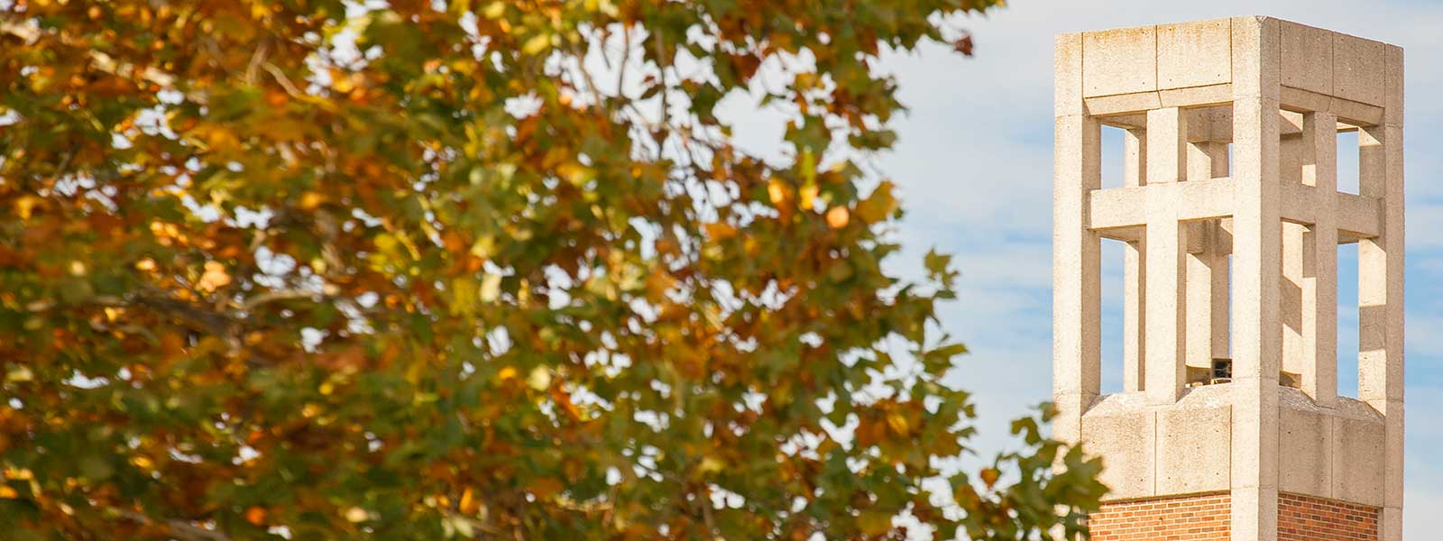 S-B-U bell tower framed by fall leaves