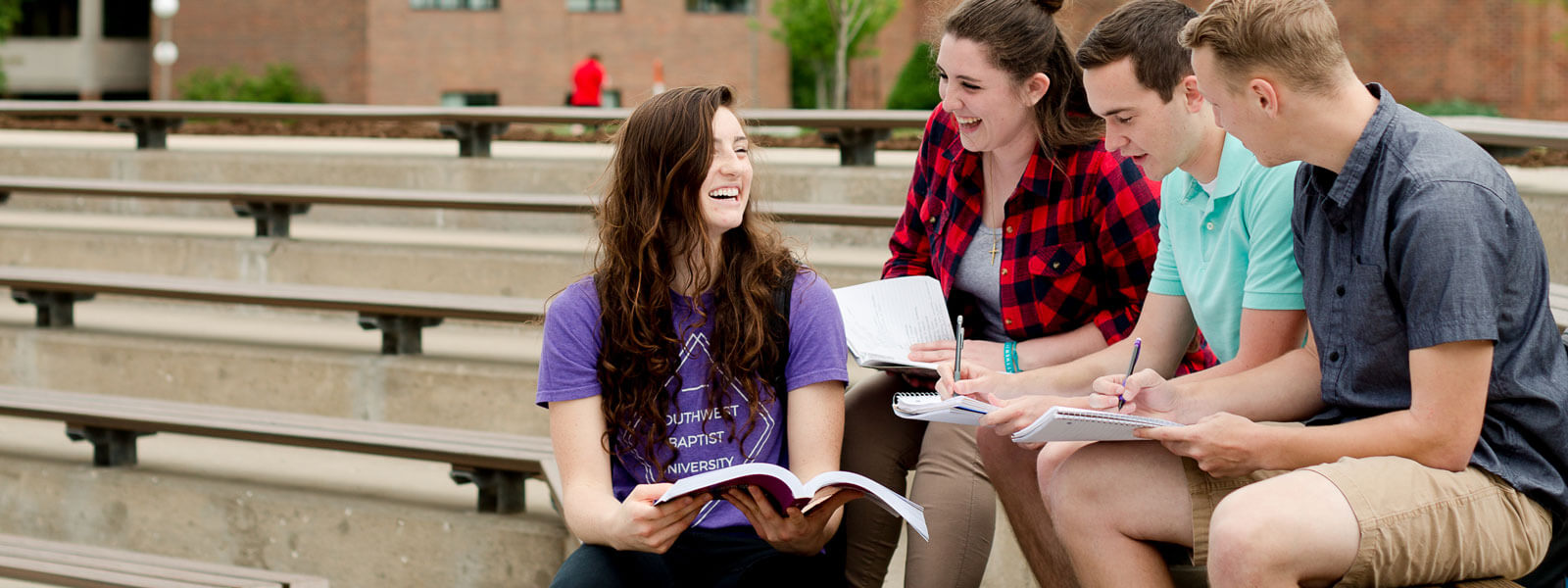 students walking on campus carrying backpacks or on phones