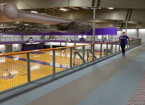male jogging on walking track above intramural gym court