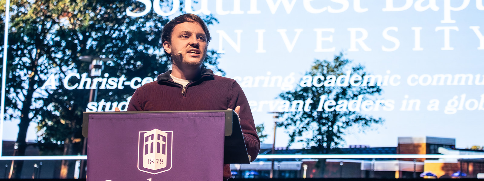 professor lectures in front of large wall map