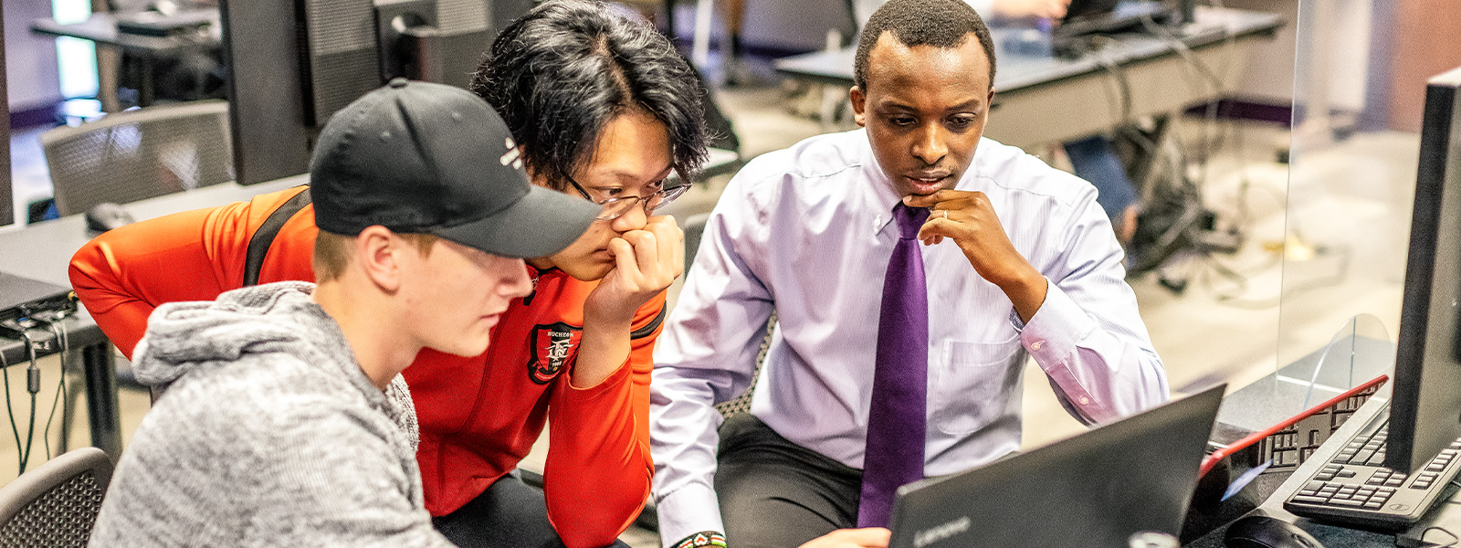student working on laptop sitting at desk