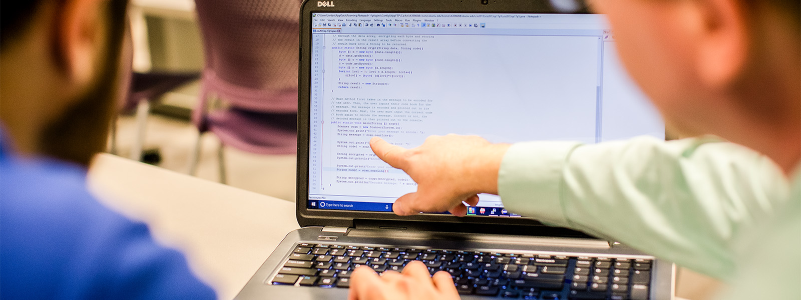student looks at computer screen while giving class presentation