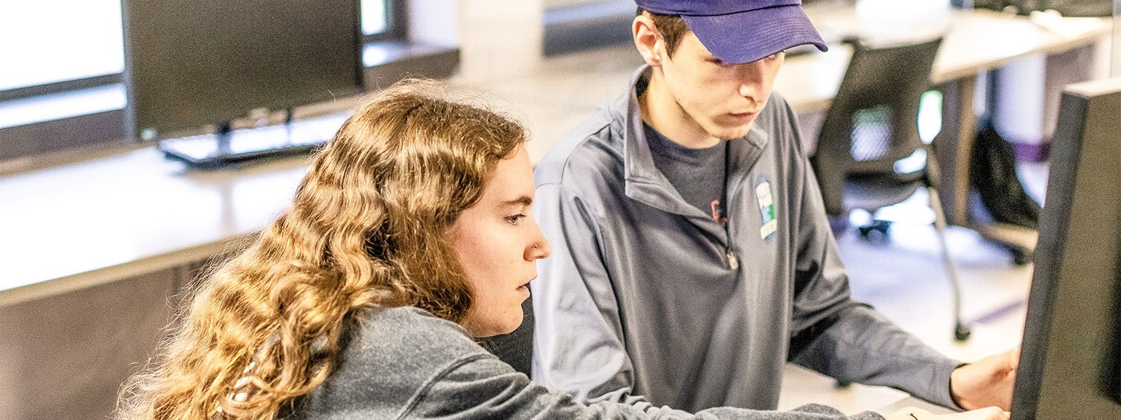 students looking at laptop screen in discussion group