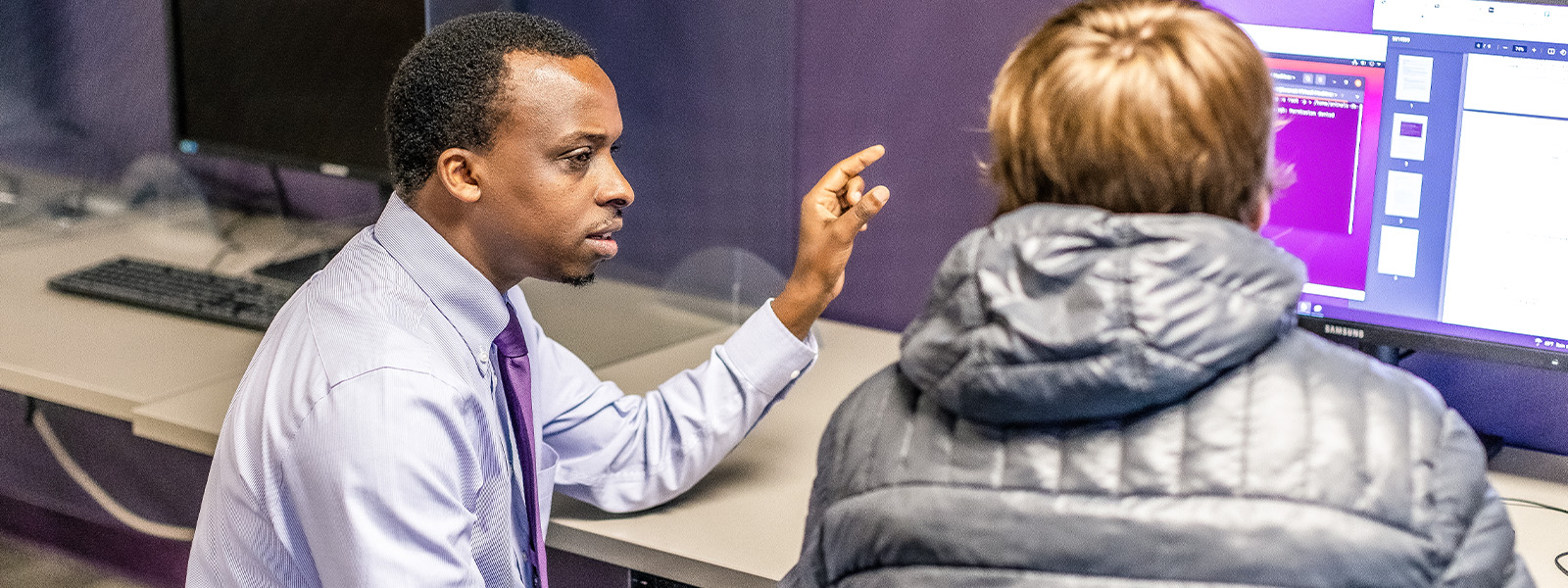 professor works with student on computer