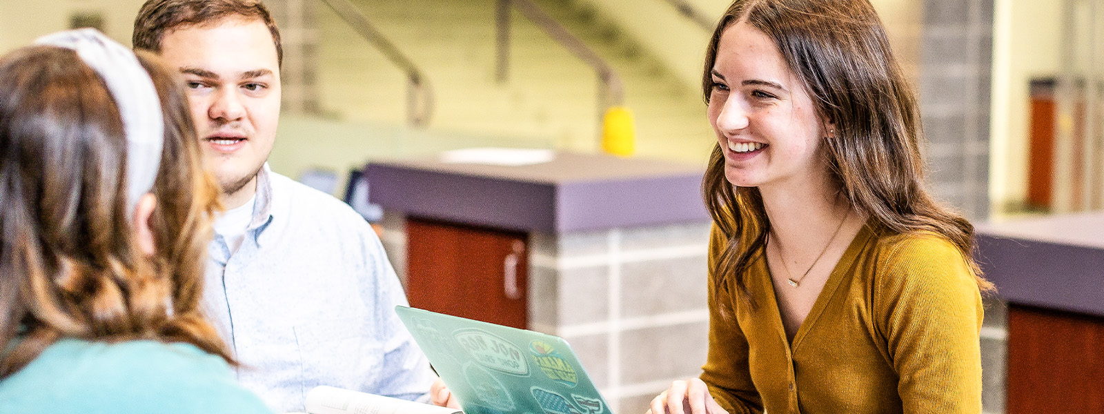 four students sitting at table studying