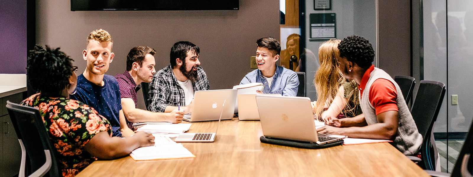 students sit around table working on group project
