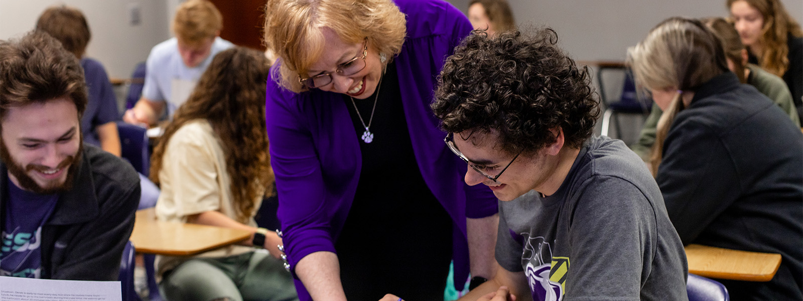 two students look at book in library