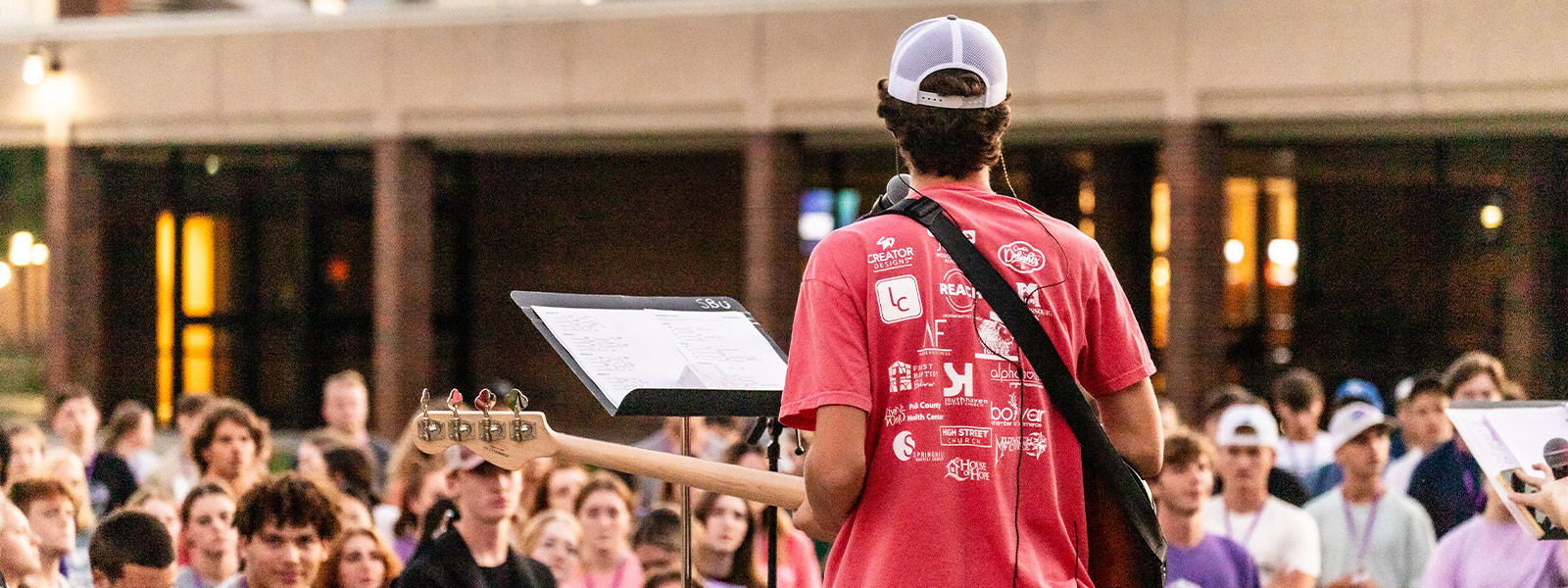 two young girls smile as they are welcomed into church camp by enthusiastic youth leaders
