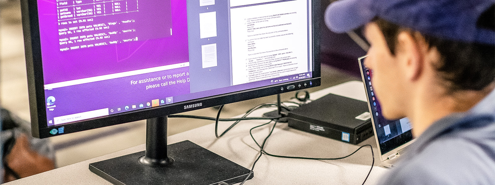 professor points to computer screen while helping student