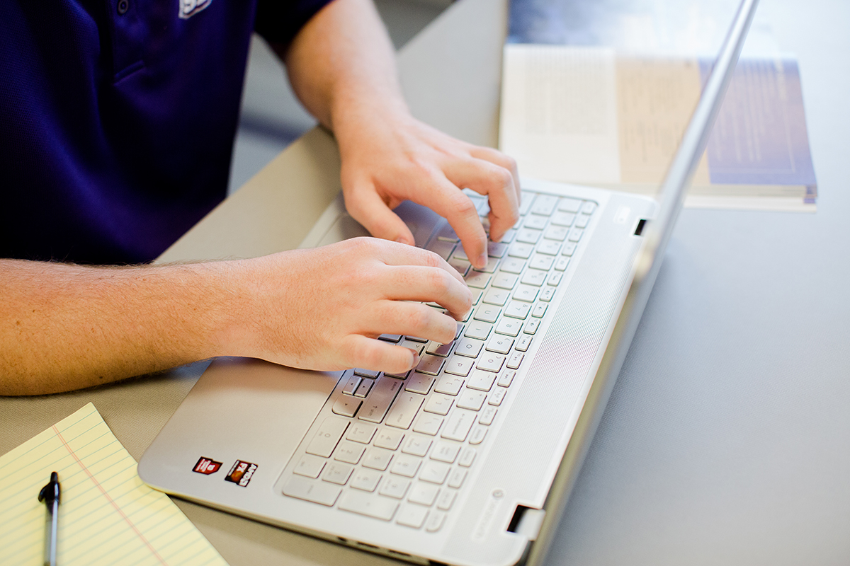 hands typing on laptop