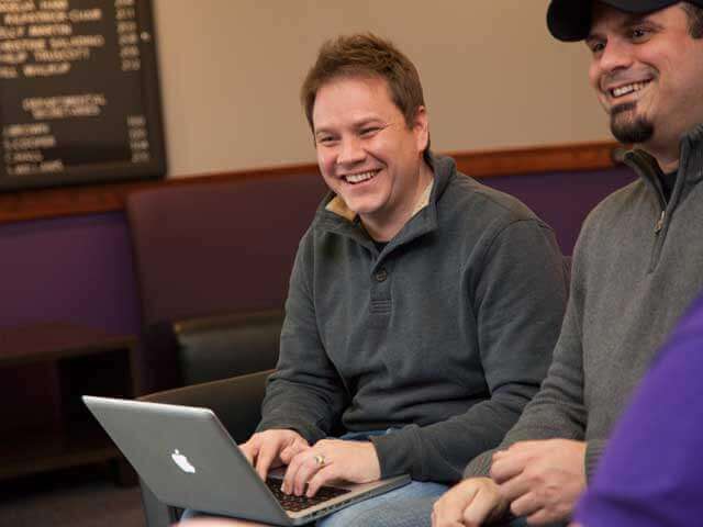 Adult male student works on laptop