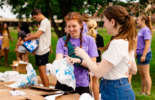 female students pack grocery bags during community outreach event