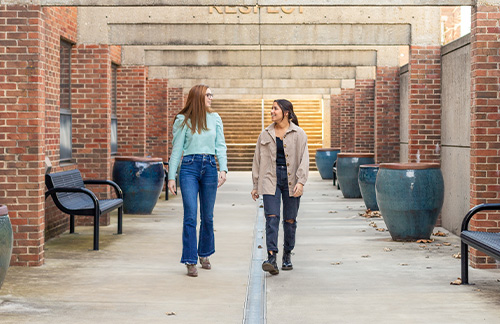 two girls walking on campus