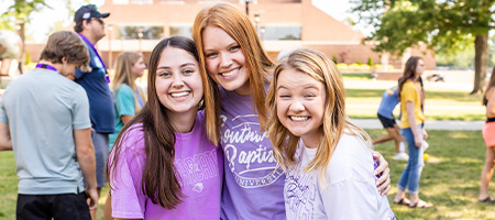 three girls linking arms at fall admissions visit event