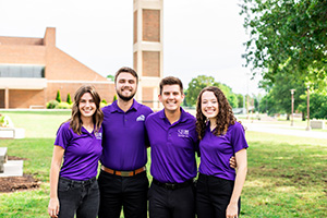 Natasha, Cooper, Jacob, and Kristen stand with arms around eachother with the bell tower in the background